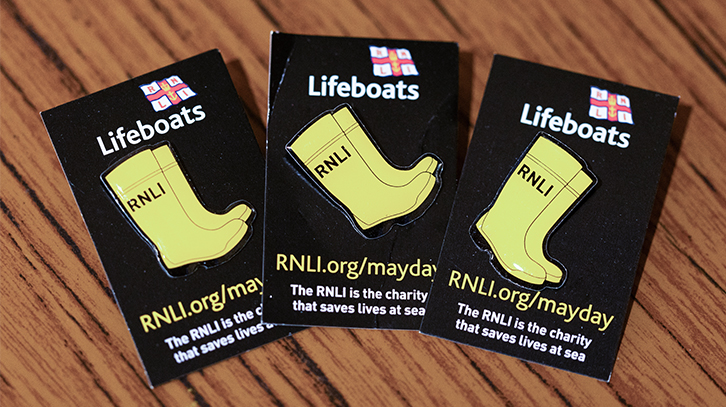 close-up of RNLI badges in the shape of yellow wellington boots