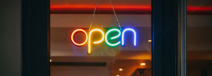 neon rainbow open sign in door window