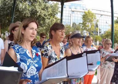 A female choir stand in line on tour, holding manuscripts to read from