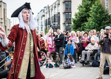 Man, dressed as Handel, conducts 150 singers and brass players in a rendition of the Hallelujah! chorus outside Bristol Cathedral