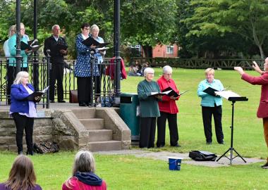 Cantiones Choir perform outdoors on a bandstand